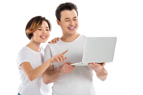 Sonriente joven pareja usando portátil aislado en blanco - foto de stock