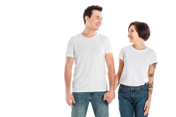 Pareja feliz tomados de la mano y mirándose aislados en blanco - foto de stock