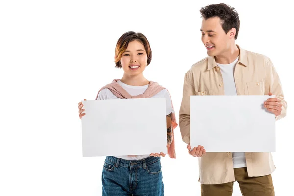 Glückliche Eheleute in lässiger Kleidung, die in die Kamera blicken und zwei leere Bretter auf weißem Grund halten — Stockfoto