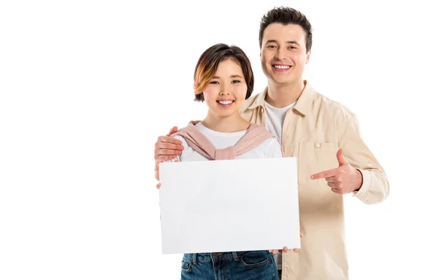 Sorrindo marido e mulher em roupas casuais olhando para a câmera e segurando placa em branco isolado no branco — Fotografia de Stock