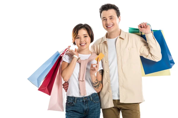 Happy couple holding shopping bags and credit card isolated on white — Stock Photo