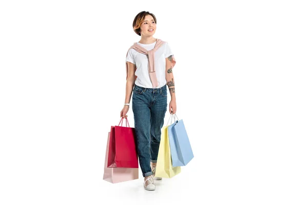 Sorridente giovane donna che tiene borse della spesa isolate su bianco — Foto stock