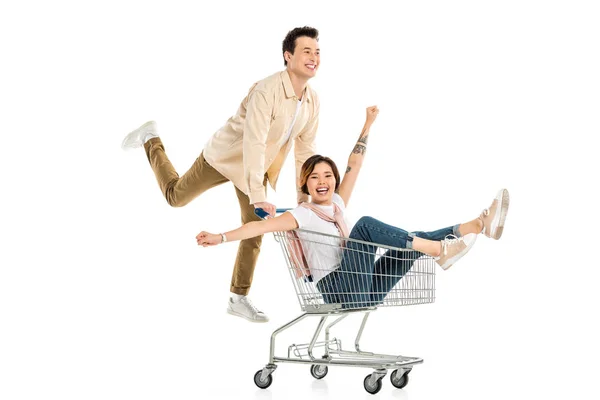 Happy husband pushing shopping cart with wife inside isolated on white, couple having fun — Stock Photo