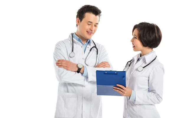 Médico feminino mostrando diagnóstico para médico do sexo masculino com braços cruzados isolados em branco — Fotografia de Stock