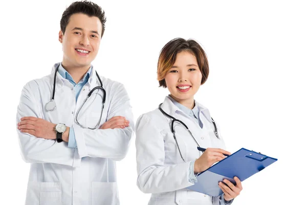 Female doctor with diagnosis and male doctor with crossed arms looking at camera isolated on white — Stock Photo