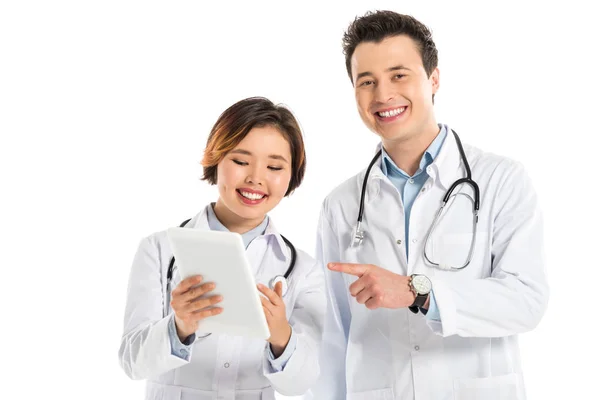 Smiling female and male doctors using digital tablet isolated on white — Stock Photo