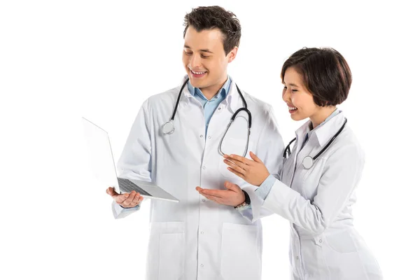 Médicos femeninos y masculinos felices usando el ordenador portátil aislado en blanco - foto de stock