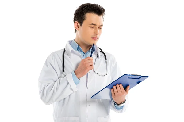 Médico masculino pensativo que sostiene el diagnóstico y la pluma aislados en blanco - foto de stock