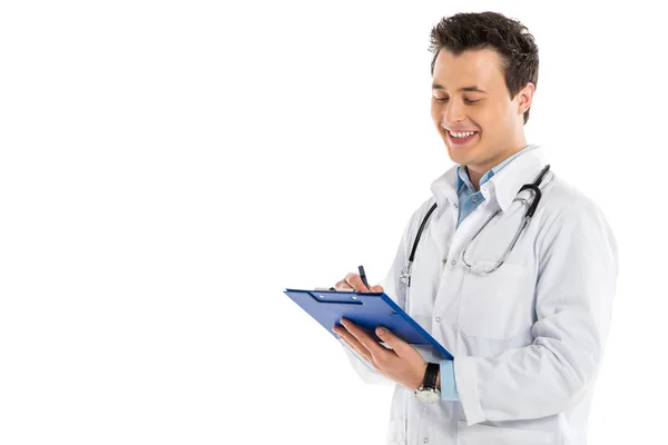 Sonriente médico masculino escribiendo diagnóstico aislado en blanco - foto de stock
