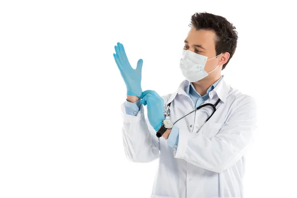 Handsome male doctor putting on rubber gloves isolated on white — Stock Photo