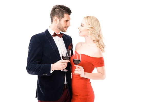 Beautiful couple clinking glasses with red wine while looking at each other isolated on white — Stock Photo