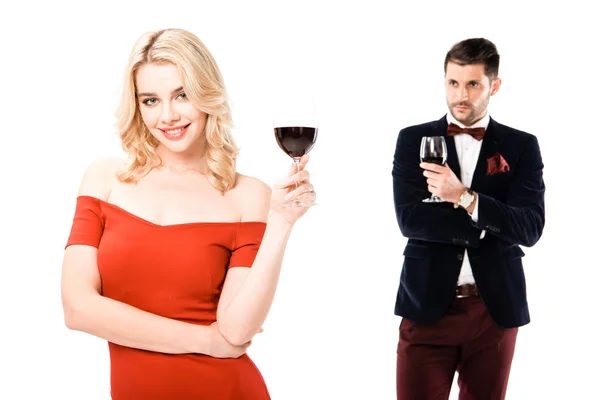 Attractive young couple holding glasses of red wine isolated on white — Stock Photo