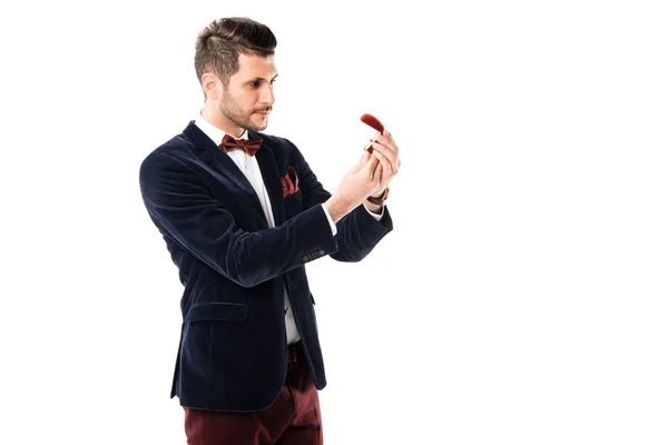 Atractivo hombre sosteniendo caja de anillo aislado en blanco - foto de stock