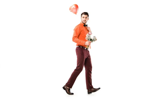 Schöner Mann mit Blumenstrauß und rotem Luftballon auf weißem Grund — Stockfoto