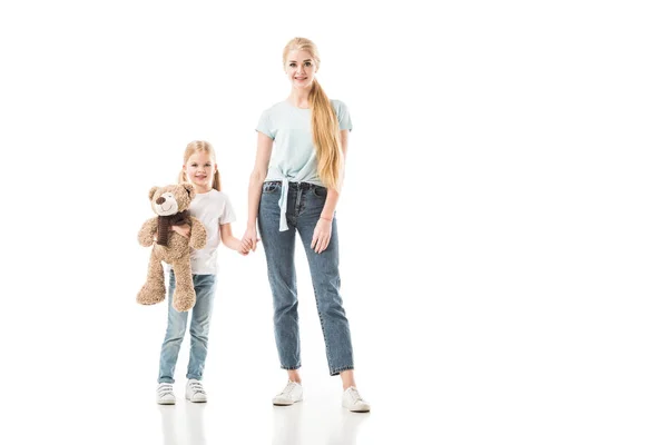 Filha com ursinho de pelúcia segurando a mão da mãe isolada no branco — Fotografia de Stock