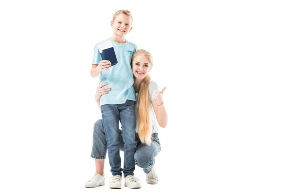 Mãe mostrando polegares para cima e filho sorrindo e segurando passaporte isolado no branco — Fotografia de Stock
