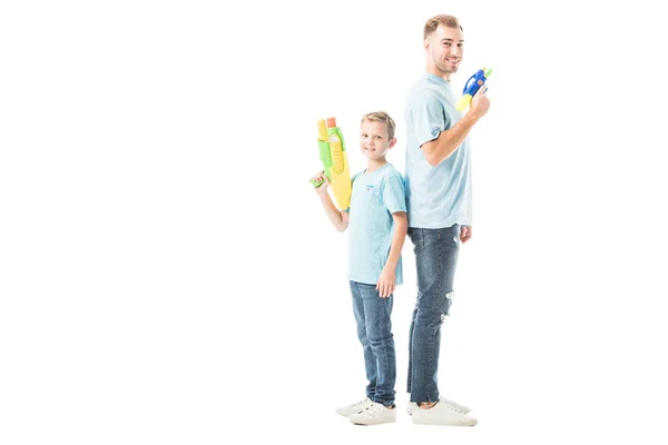 Pai e filho brincando com armas de água e sorrindo isolado no branco — Fotografia de Stock