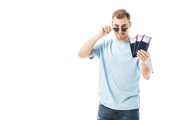Веселий чоловік стоїть в сонцезахисних окулярах з паспортами ізольовано на білому — стокове фото