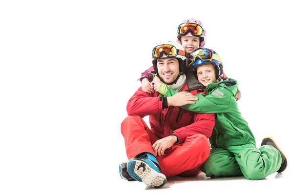 Vater sitzt und umarmt Kinder in Schneeanzügen und lächelt isoliert auf weißem Grund — Stockfoto