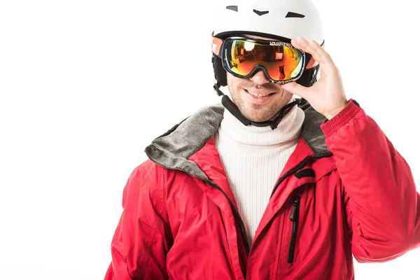 Erwachsener Mann in roter Skijacke und Helm setzt Schutzbrille auf und lächelt isoliert auf weißem Grund — Stockfoto