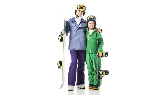 Young mom and preteen son in ski suits with snowboards hugging isolated on white — Stock Photo
