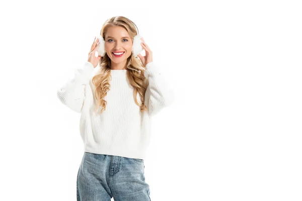Sonriente mujer tocando orejeras de invierno aislado en blanco - foto de stock