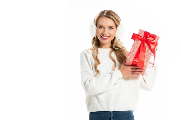 Beautiful smiling girl in winter outfit holding gift box isolated on white — Stock Photo