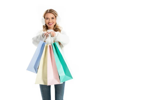 Atractiva mujer en traje de invierno sosteniendo bolsas de compras aisladas en blanco - foto de stock