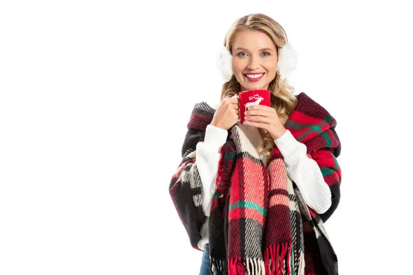 Bella donna sorridente in coperta calda tenendo tazza di caffè isolato su bianco — Foto stock