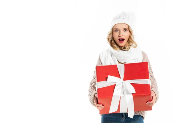 Здивований дівчина в зими спорядження, проведення великий червоний подарунок ізольовані на білому — стокове фото