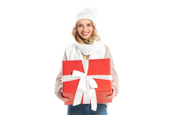 Посміхається дівчина в зими спорядження, проведення великий червоний подарунок ізольовані на білому — стокове фото