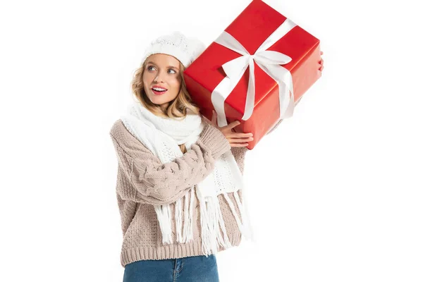Attractive woman in winter outfit holding big red present isolated on white — Stock Photo