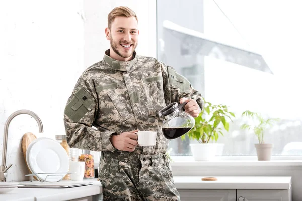 Soldado do exército sorrindo derramando café filtrado na cozinha — Fotografia de Stock