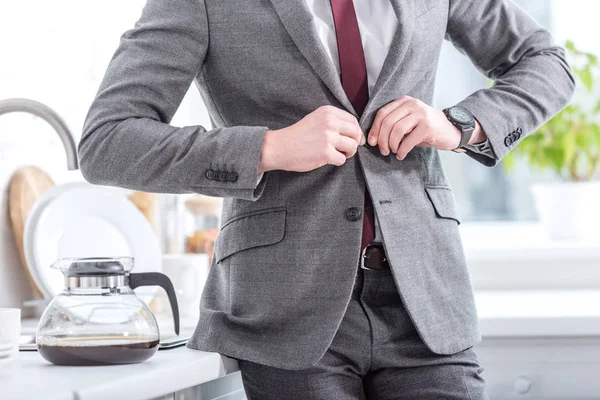 Cropped view of businessman fixing button on suit — Stock Photo