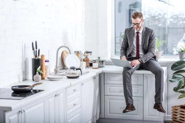 Бізнесмен працює на ноутбуці на кухні вдома — стокове фото