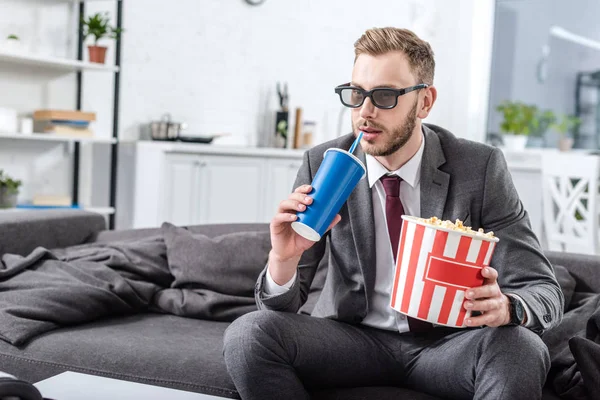 Schöner Geschäftsmann auf der Couch in 3D-Gläsern mit Popcorn und Sodawasser — Stockfoto