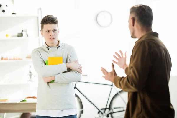 Irritated father gesturing and looking at teen son at home — Stock Photo