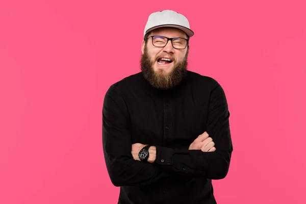 Young bearded man with crossed arms doing grimace isolated on pink — Stock Photo