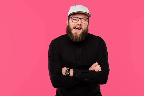 Jeune homme barbu avec les bras croisés faisant grimace isolé sur rose — Photo de stock