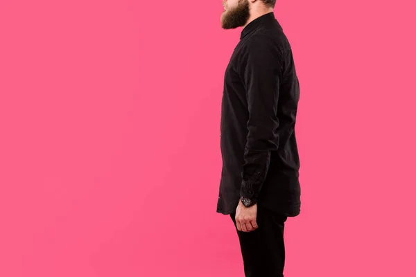 Vista parziale di uomo barbuto in camicia nera elegante posa isolata su rosa — Foto stock