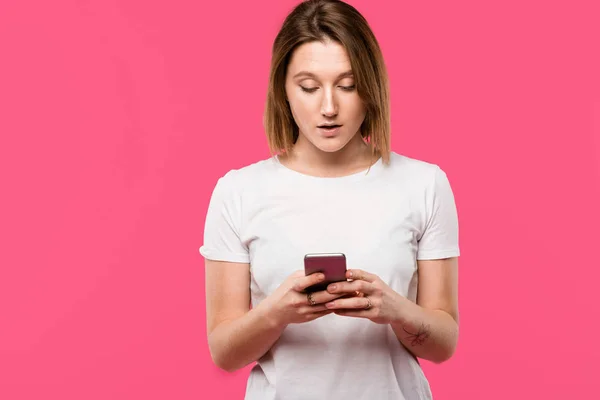 Belle fille en utilisant smartphone isolé sur rose — Photo de stock