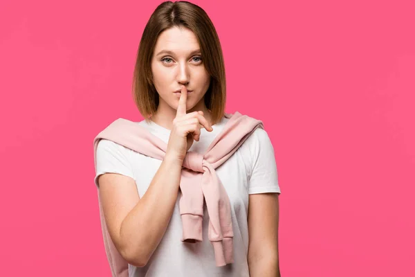 Stylish woman looking at camera and doing silence gesture isolated on pink — Stock Photo
