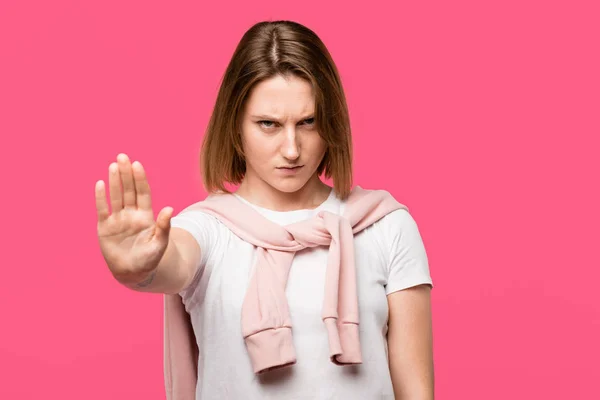 Mujer joven agresiva mostrando gesto de stop aislado en rosa - foto de stock