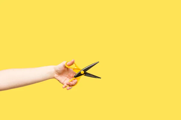 Plan recadré d'une personne tenant des ciseaux isolés sur du jaune — Photo de stock