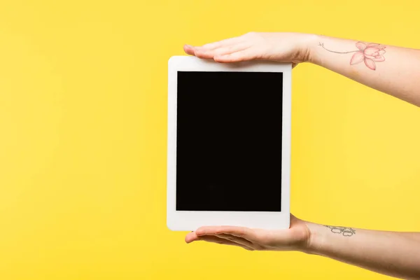 Обрізаний знімок людини, що тримає цифровий планшет з порожнім екраном ізольовано на жовтому — стокове фото