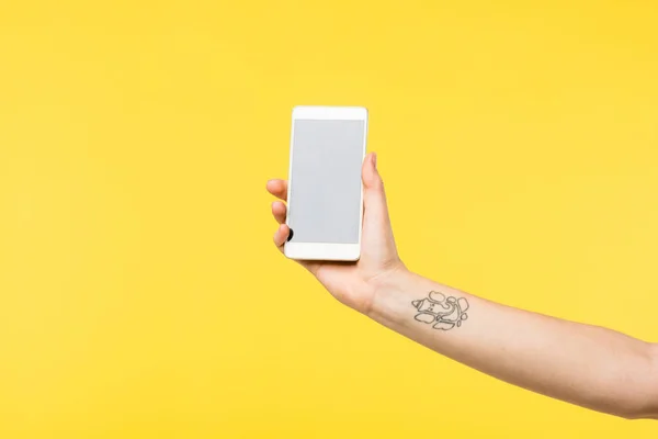 Cropped shot of girl holding smartphone with blank screen isolated on yellow — Stock Photo