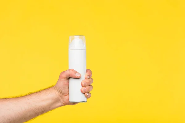 Cropped shot of person holding container with shaving foam isolated on yellow — Stock Photo