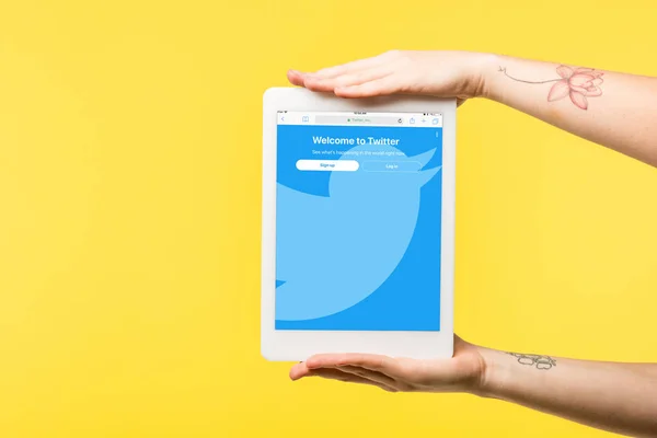 Plan recadré de la personne tenant tablette numérique avec application twitter isolé sur jaune — Photo de stock