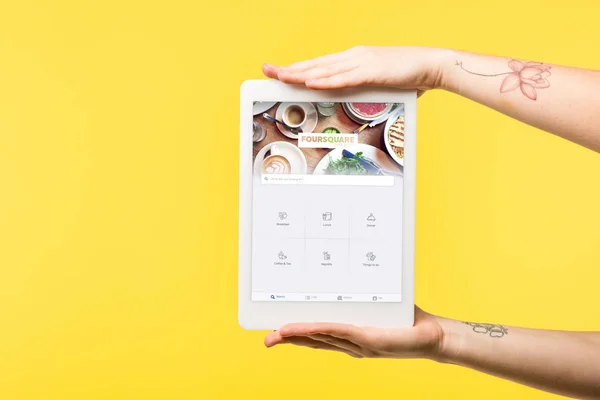 Abgeschnittene Aufnahme einer Person, die ein digitales Tablet mit viereckiger Webseite auf dem Bildschirm hält, isoliert auf gelb — Stockfoto