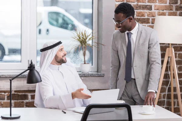 Arabo uomo d'affari parlando con partner afro-americano — Foto stock